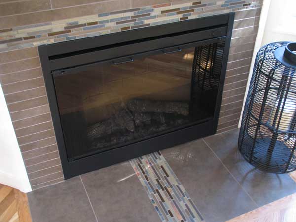 Fireplace tile with a modern approach using stone, porcelain, and glass.